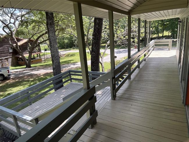 Charming covered porch with serene lake views. | Image 24