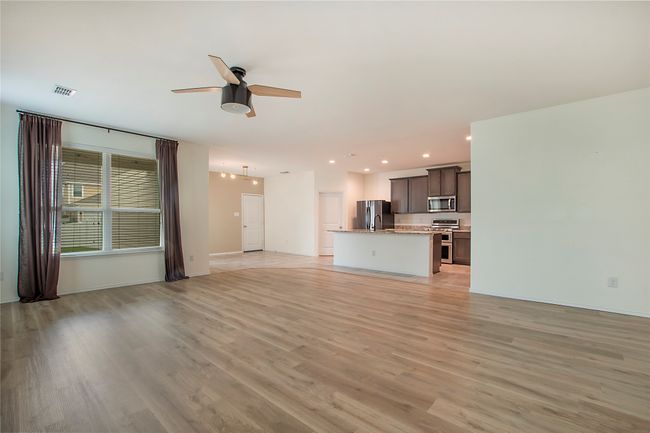Unfurnished living room featuring a ceiling fan, light wood-style flooring, and recessed lighting | Image 8