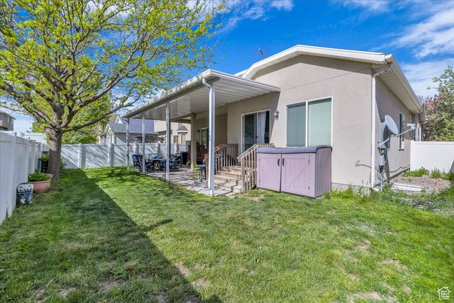 Rear view of house with a patio, a fenced backyard, stucco siding, and a yard | Image 26