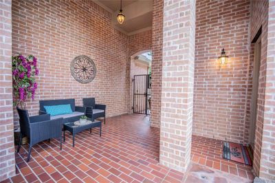 Enter from the front iron gate into the covered porch and court yard, providing a welcoming entrance to the home. | Image 3