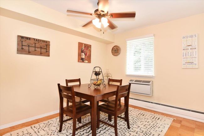 Dining space featuring a baseboard radiator, ceiling fan, and a wall mounted air conditioner | Image 15