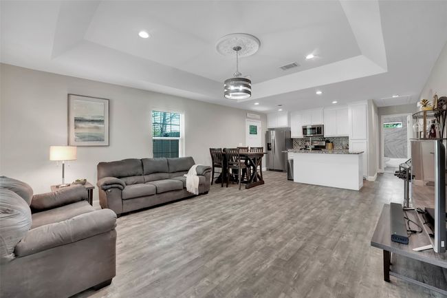 Living area featuring recessed lighting, visible vents, light wood-type flooring, and a raised ceiling | Image 12