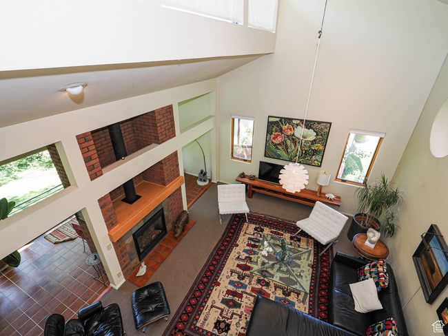 Living area featuring a brick fireplace, a high ceiling, and healthy amount of natural light | Image 12