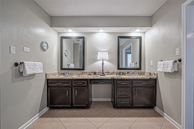 Luxurious primary bathroom with dual vanities and ample cabinet storage. | Image 30
