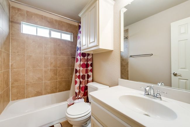 Bathroom with toilet, vanity, and shower / tub combo with curtain | Image 21