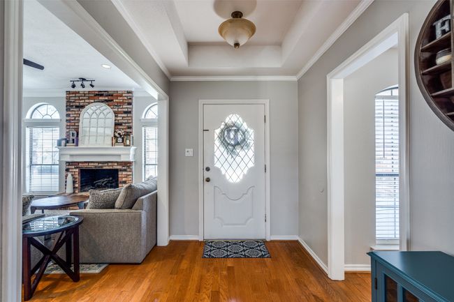 Foyer entrance with wood finished floors, baseboards, and crown molding | Image 4