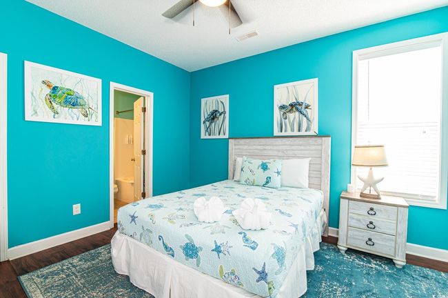 Bedroom with wood finished floors, baseboards, multiple windows, and connected bathroom | Image 14