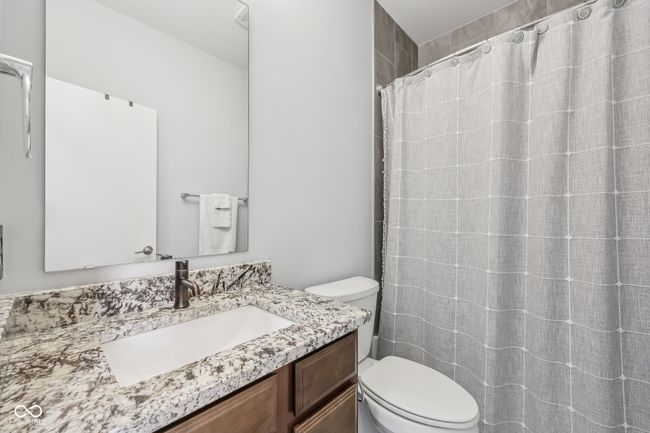 full bathroom with curtained shower, toilet, and vanity | Image 18