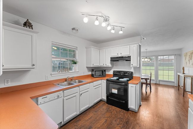 Kitchen with electric range, dishwasher, stainless steel microwave, under cabinet range hood, and light countertops | Image 13