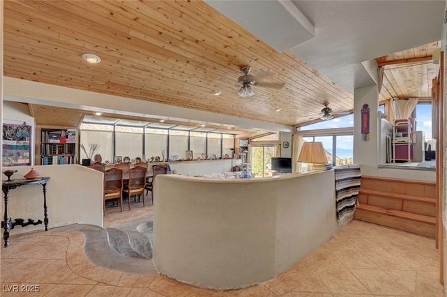 Living room featuring tile patterned floors, a ceiling fan, wood ceiling, and lofted ceiling | Image 34