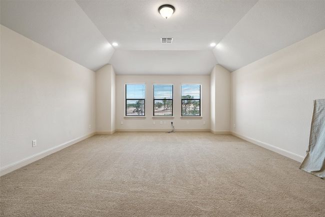 Spare room featuring light colored carpet, lofted ceiling, and recessed lighting | Image 34