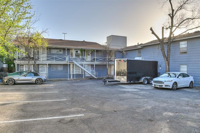 View of building exterior with stairway and uncovered parking | Image 13