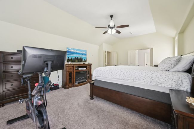 Carpeted bedroom featuring ceiling fan and lofted ceiling | Image 23