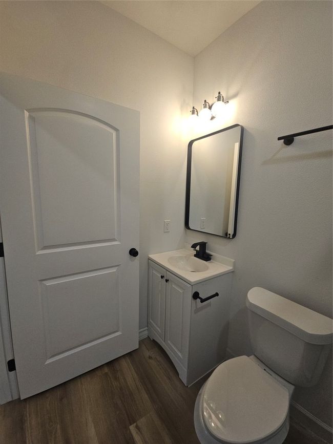 Bathroom featuring toilet, wood finished floors, and vanity | Image 11