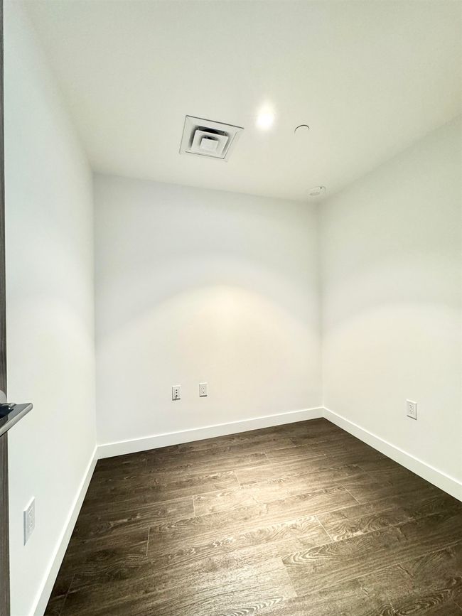 Spare room with dark wood finished floors, baseboards, and visible vents | Image 7