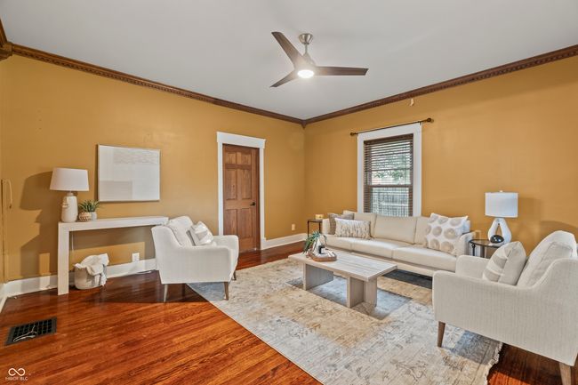 living area with wood finished floors, crown molding, and ceiling fan | Image 8