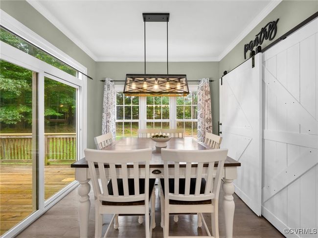 Eat in area featuring crown molding and a barn door | Image 7