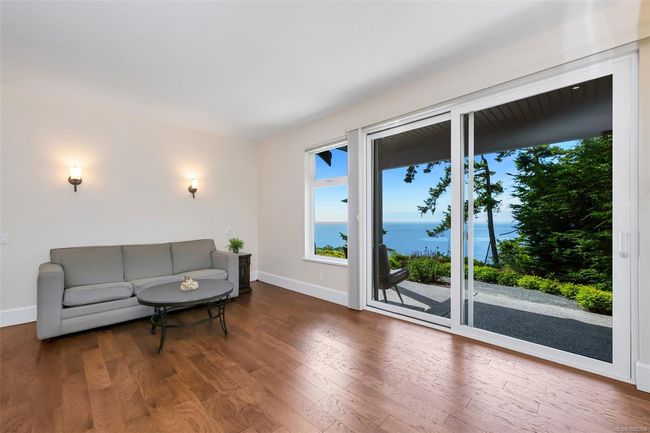 Living area with wood finished floors and a water view | Image 86