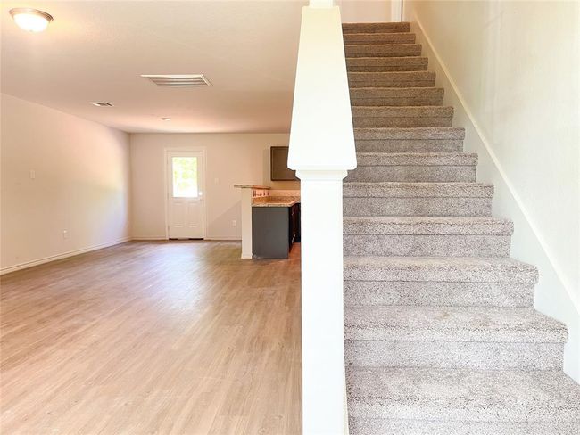 Inviting carpeted staircase leading to upstairs bedrooms | Image 9