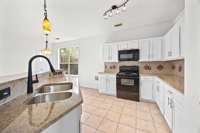 This country kitchen has new granite countertops and sink fixture. | Image 13