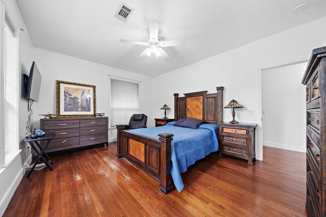 Inviting bedroom with large windows and neutral walls | Image 32
