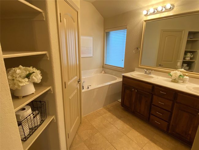 Full bathroom featuring a bath, a sink, tile patterned flooring, and double vanity | Image 17