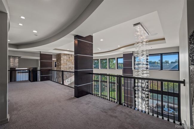 Corridor with a raised ceiling, carpet, a chandelier, and recessed lighting | Image 19
