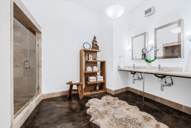 Primary ensuite bathroom with stained concrete flooring and a large natural stone walk-in shower | Image 30
