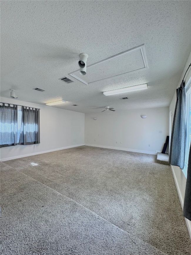 Empty room featuring a textured ceiling and a ceiling fan | Image 26