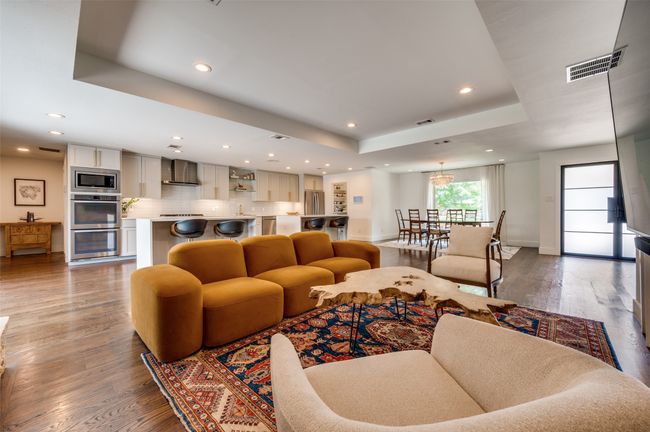 Living room with a raised ceiling, wood finished floors, recessed lighting, and baseboards | Image 11