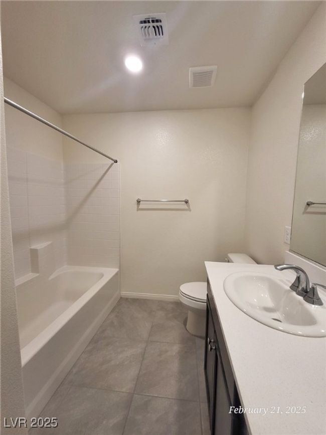 Bathroom featuring visible vents, toilet, vanity, shower combination, and baseboards | Image 13