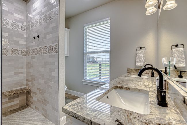 Primary bathroom featuring a walk-in shower and double vanity | Image 25