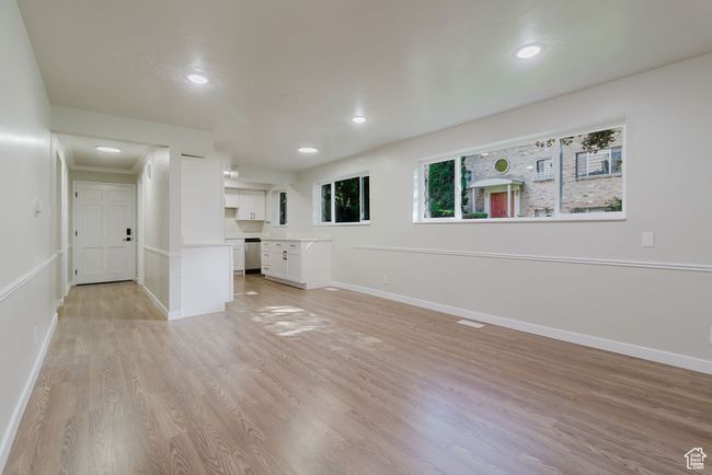Unfurnished living room featuring baseboards, light wood finished floors, recessed lighting, and visible vents | Image 7