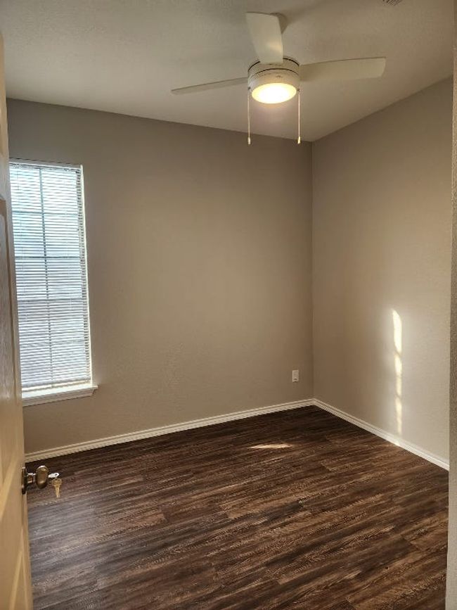 Empty room with baseboards, dark wood-style floors, and ceiling fan | Image 9
