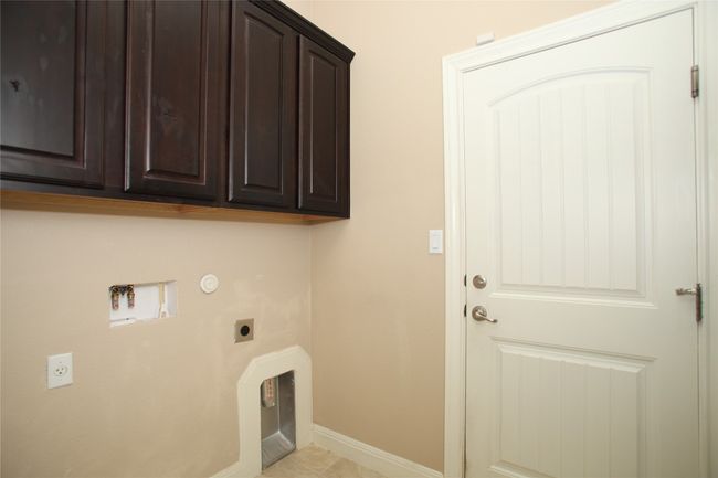 Laundry area with electric dryer hookup, cabinet space, baseboards, washer hookup, and hookup for a gas dryer | Image 33