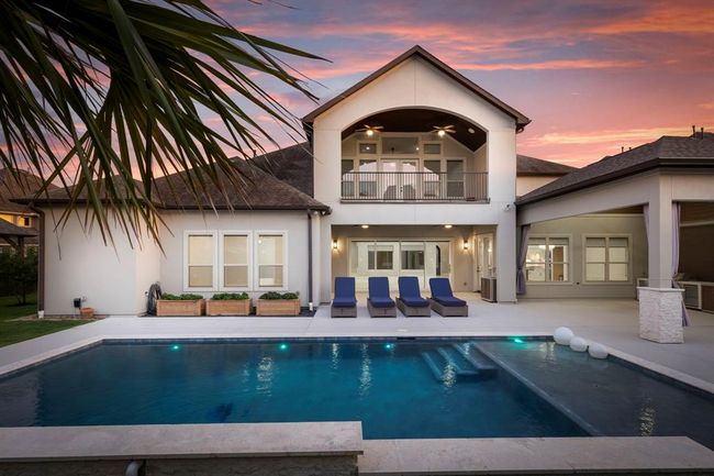 The symmetry of the custom heated pool, the upper balcony, and the sleek covered patio create a cohesive indoor-outdoor living experience. Lush planters, ambient lighting, and designer loungers bring both sophistication and functionality to this entertainer’s dream. | Image 42