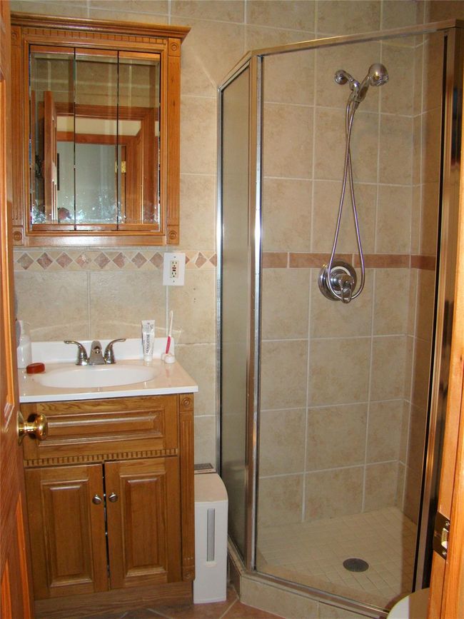 Bathroom featuring tasteful backsplash, vanity, and an enclosed shower | Image 21