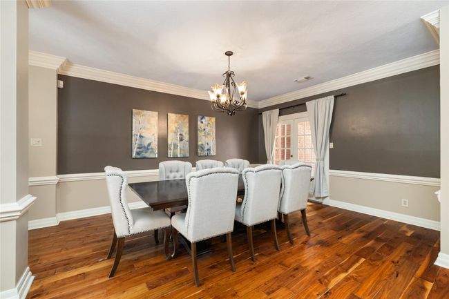 With rich wood floors, classic crown molding, chair rail accents, and French doors leading to the front patio, this dining room offers a polished yet comfortable setting for holidays, celebrations, or casual meals alike. | Image 14