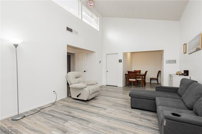 Living room featuring a towering ceiling and light wood-style flooring | Image 8