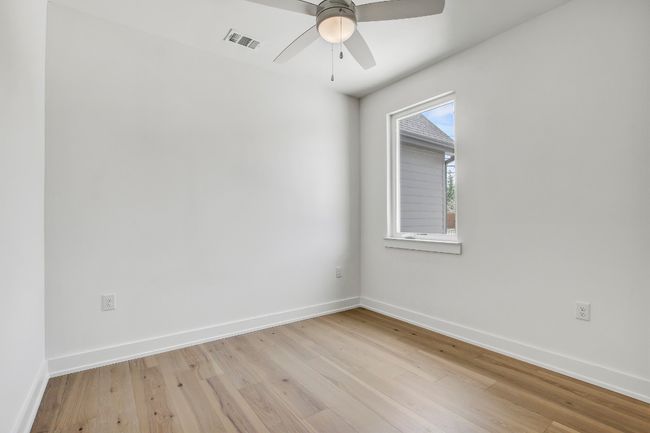 Empty room with light wood-style floors, ceiling fan, and baseboards | Image 26