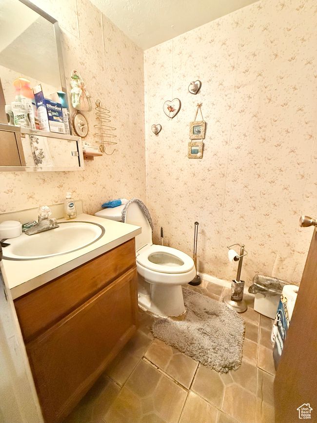 Half bathroom featuring vanity, wallpapered walls, and tile patterned floors | Image 10