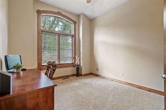 Adjacent to the entryway, this room could be used as a second bedroom on the man level or ideal home office. The oversized window allows natural light to fill the room! 10' ceilings, neutral carpet and walls are such a bonus. | Image 21