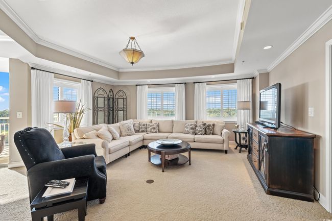 Living room with a tray ceiling, crown molding, light colored carpet, and recessed lighting | Image 9