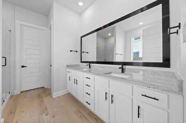 Master bathroom includes granite countertop, elongated mirror, and dual-vanity sinks. | Image 6