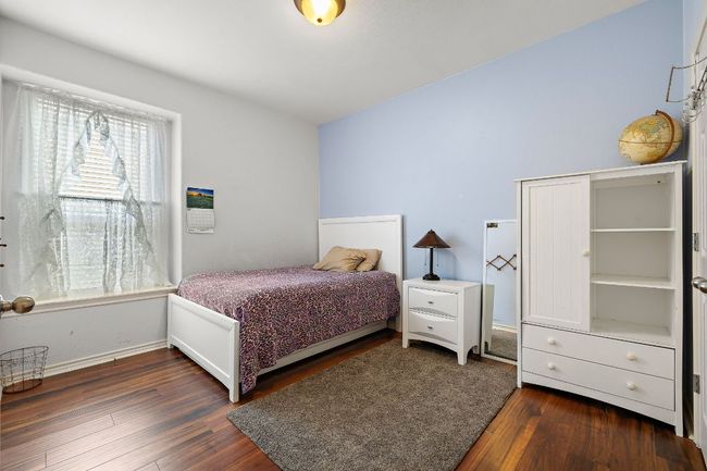 Bedroom featuring dark wood finished floors and windows | Image 21