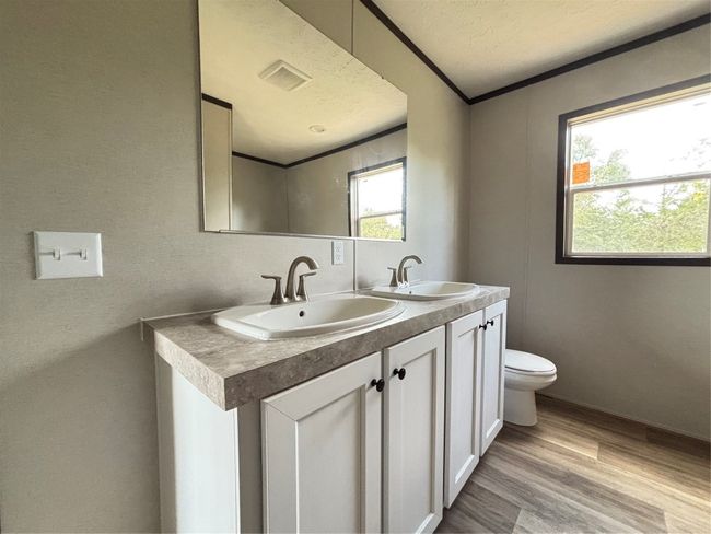Full bath with wood lock finished floors, double vanity, and a textured ceiling | Image 11