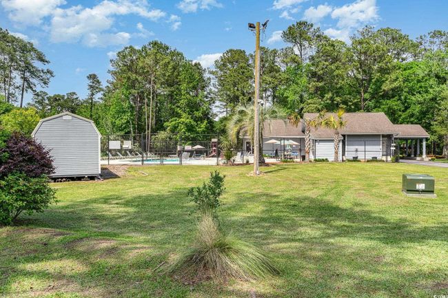 View of yard with fence, a fenced in pool, a shed, and an outbuilding | Image 24