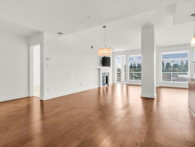 Unfurnished living room featuring wood finished floors and a glass covered fireplace | Image 11