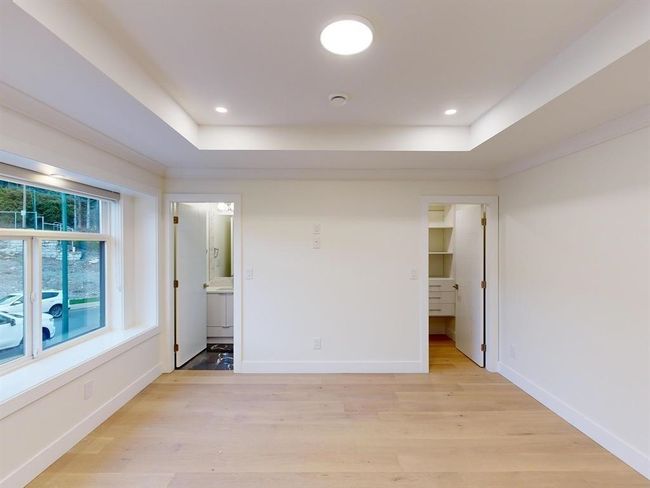 Empty room featuring a tray ceiling, light wood finished floors, recessed lighting, and a smoke detector | Image 36