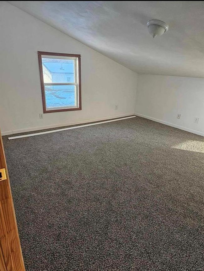 Carpeted spare room with baseboards and lofted ceiling | Image 17